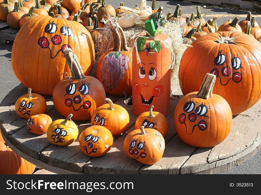 Pumpkins painted with cheerful, colorful faces. Pumpkins painted with cheerful, colorful faces