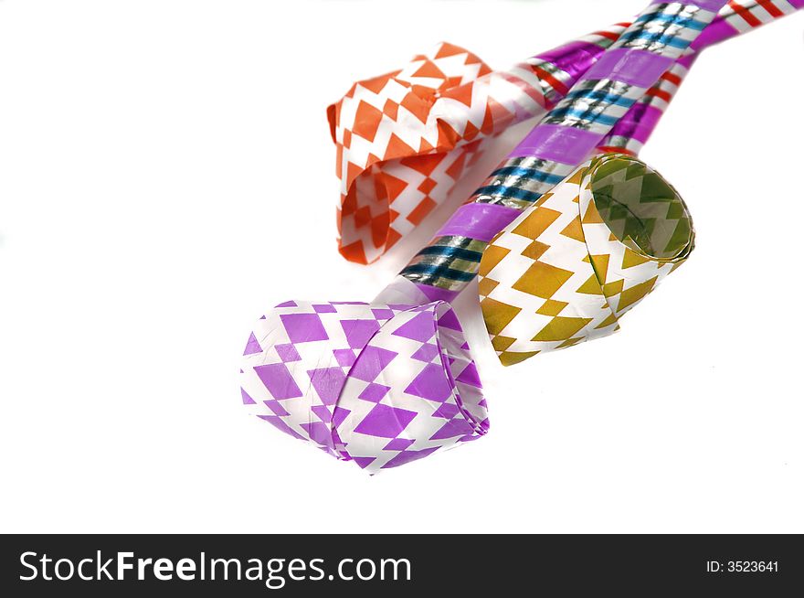 Three party blowers or noisemakers on a white background