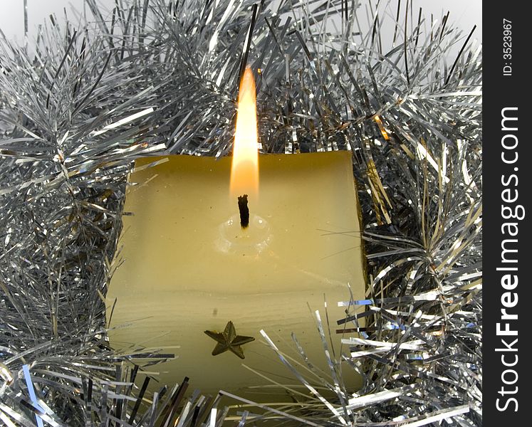 Yellow candle with fire in silver christmas chain