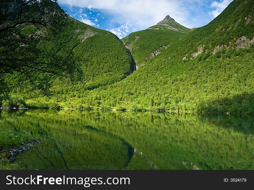 Lush green mountain reflecting in a lake. Lush green mountain reflecting in a lake