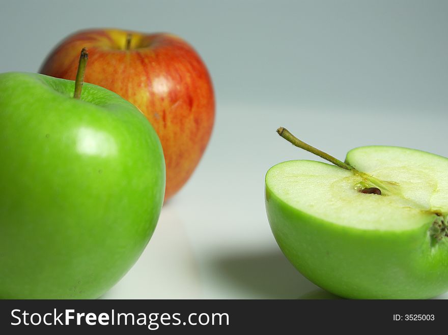 Three greenand red apples on white background