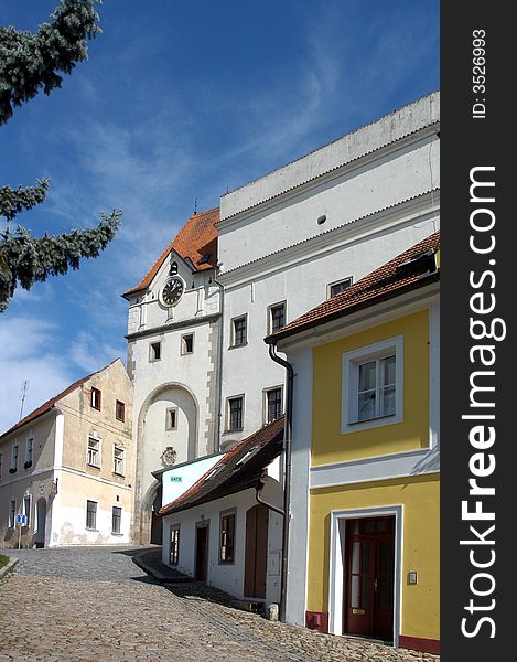 A street of a historic town leading to a castle gate. A street of a historic town leading to a castle gate