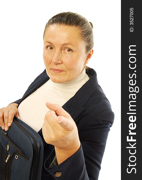 Serious older businesswoman holding a binder and pointing at the camera with the focus on the hand; isolated on white. Serious older businesswoman holding a binder and pointing at the camera with the focus on the hand; isolated on white