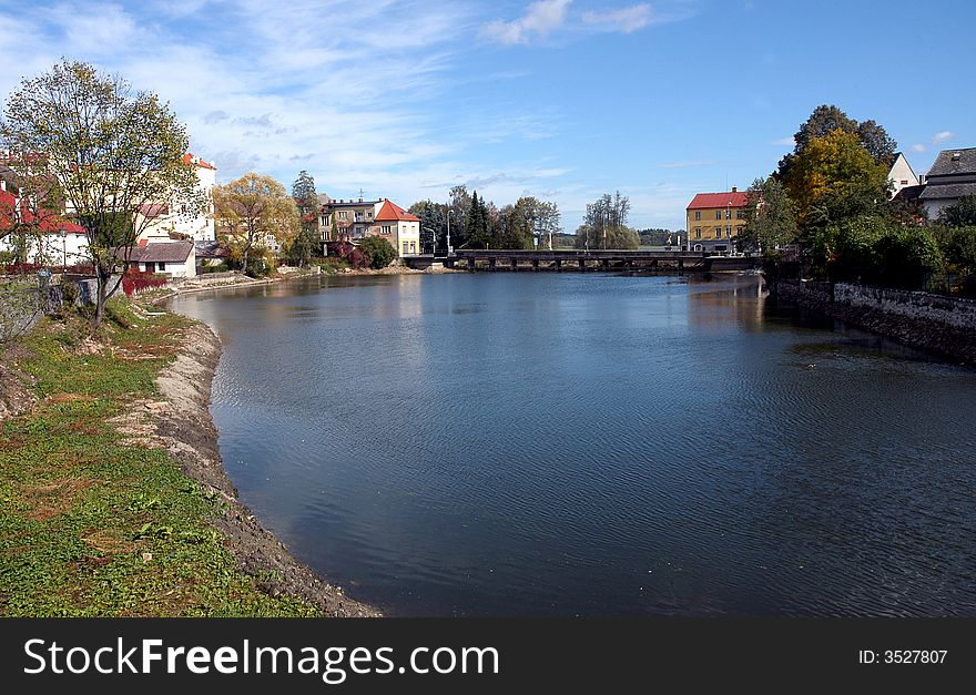 A river with several houses on a bank. A river with several houses on a bank