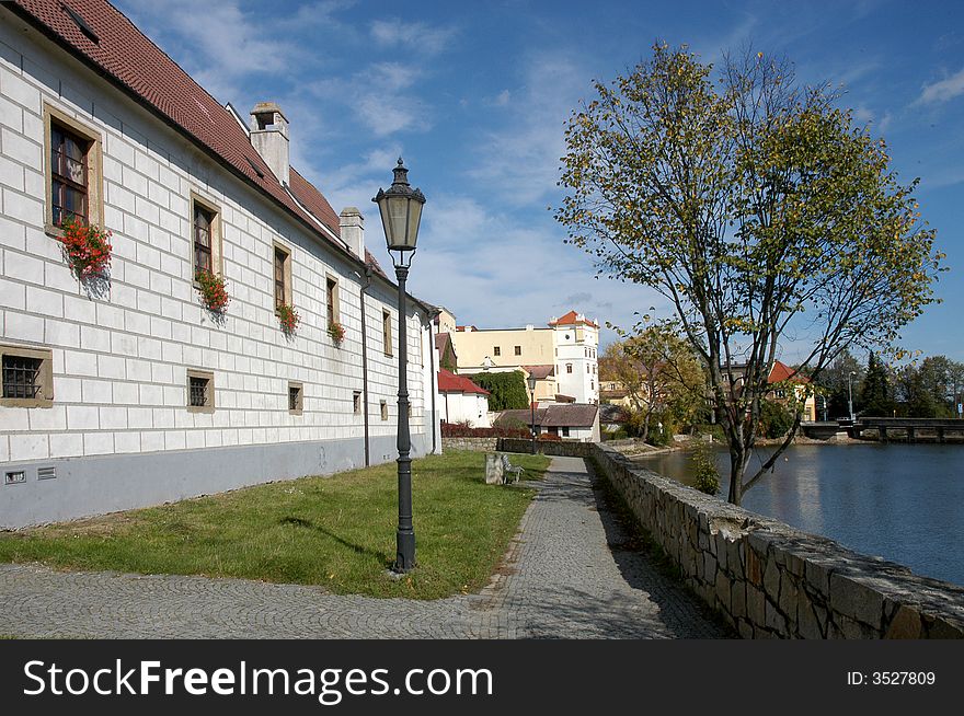 A river with several old houses  and a lantern on a bank. A river with several old houses  and a lantern on a bank