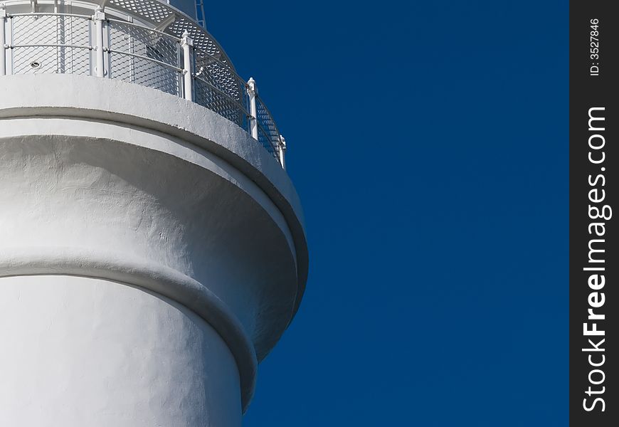 Detail of white lighthouse balcony with clear blue sky