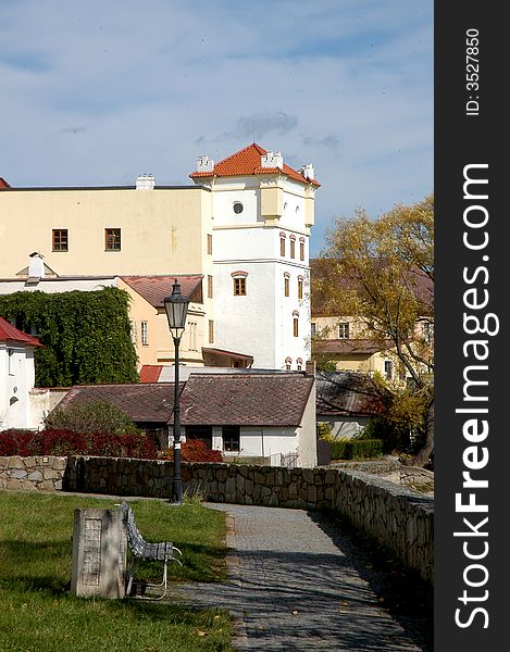 A view of an old town with a bench, pavement and old buildings