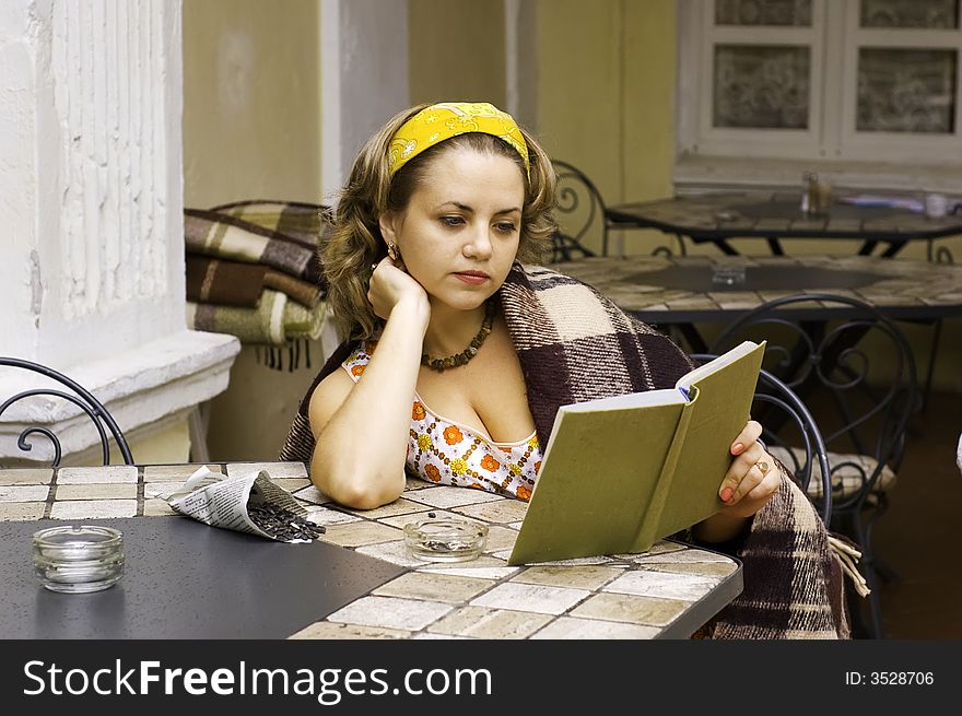 Beautiful woman is reading book at home porch. Beautiful woman is reading book at home porch