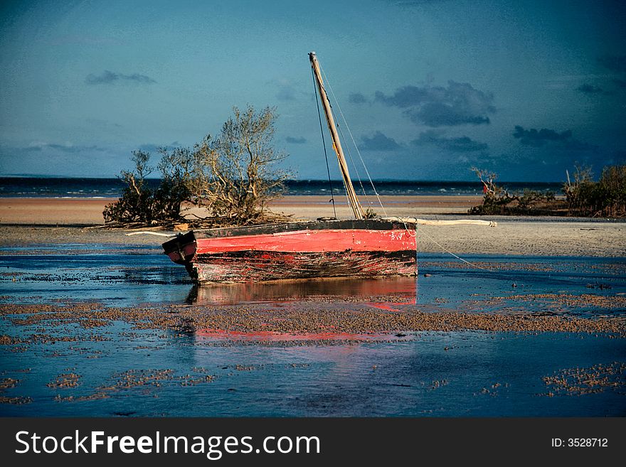 Black and red dhow lying in the calm waters of the bay of Pemba next to the Indian ocean. Black and red dhow lying in the calm waters of the bay of Pemba next to the Indian ocean.