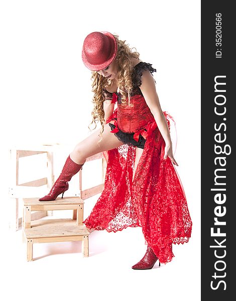 Actress in a red dress and hat posing on a wooden ladder on white background