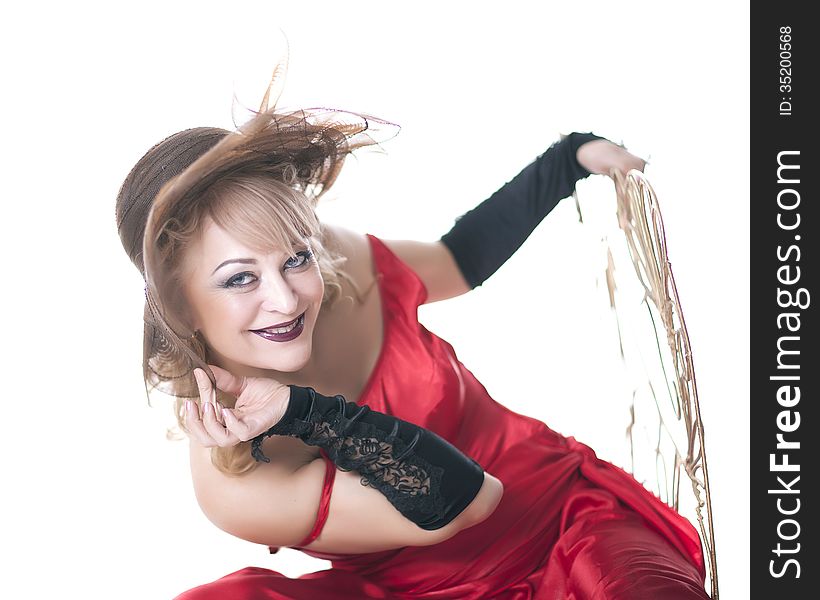 Woman in a red dress posing on a chair on a white background