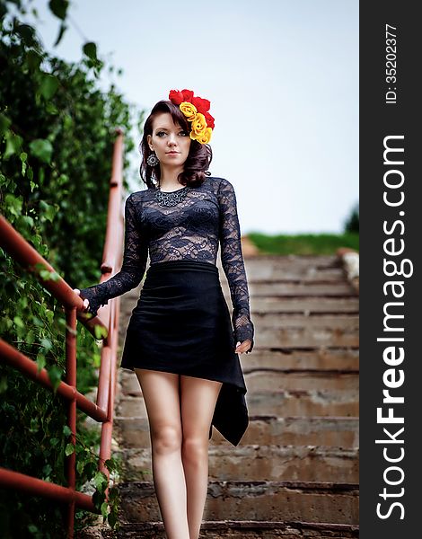 Fashion portrait of woman in black lace dress on stairs