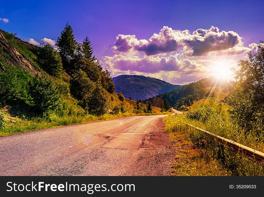 Empty asphalt mountain road with Painted single white Line near the coniferous forest with cloudy sky in morning light. Empty asphalt mountain road with Painted single white Line near the coniferous forest with cloudy sky in morning light