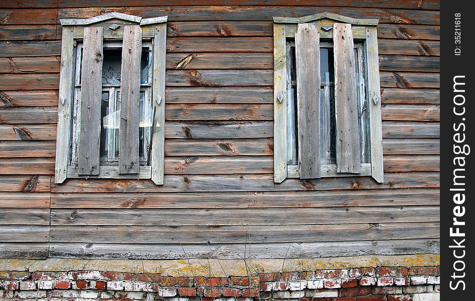Broken And boarded windows of an old abandoned farmhouse