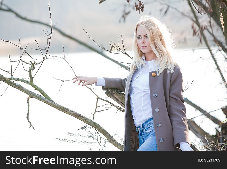 Young beautiful blonde girl in the autumn river. Young beautiful blonde girl in the autumn river