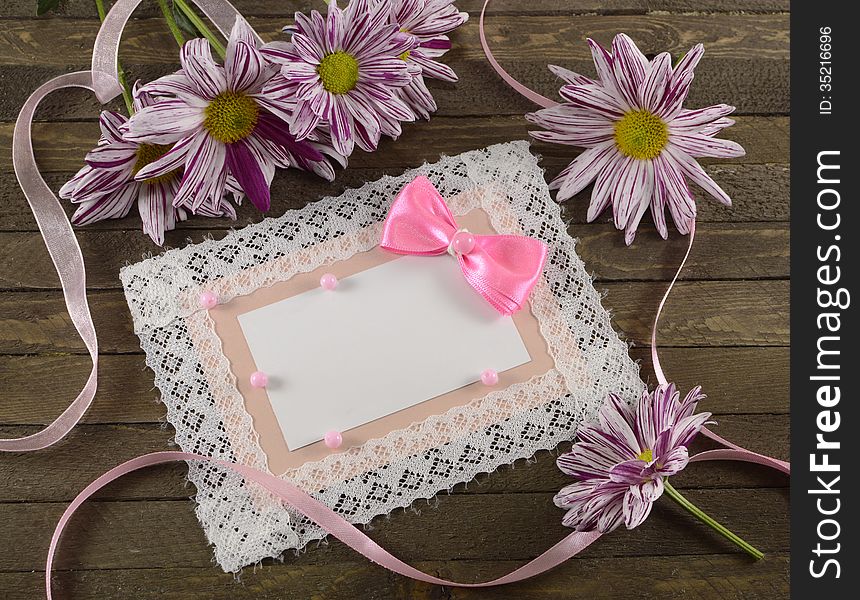 Pink greeting card with flowers on wooden background. Pink greeting card with flowers on wooden background