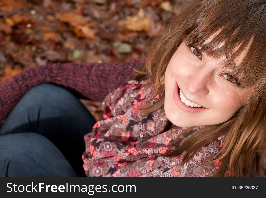 Smiling Girl On The Autumn Ground