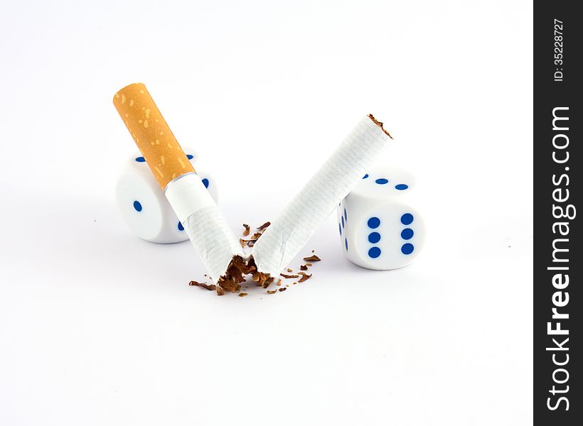 Broken cigarette with two dices. Broken cigarette with two dices