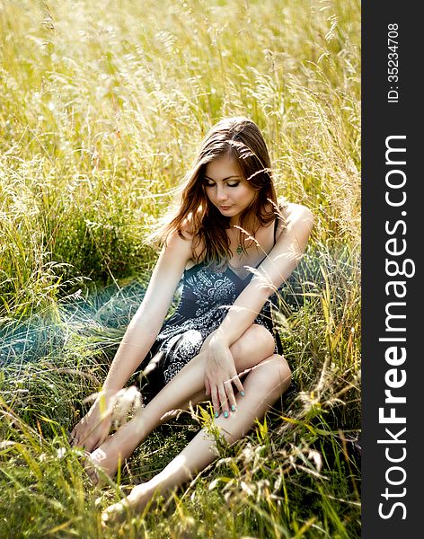 Relaxed woman sitting in sunny field