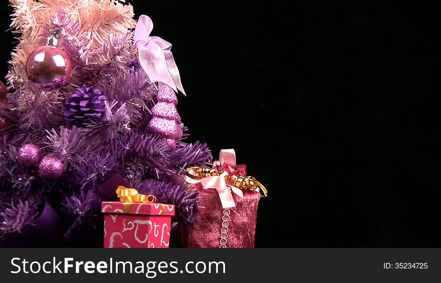 Decorated pink Christmas tree rotates on a black background. Decorated pink Christmas tree rotates on a black background