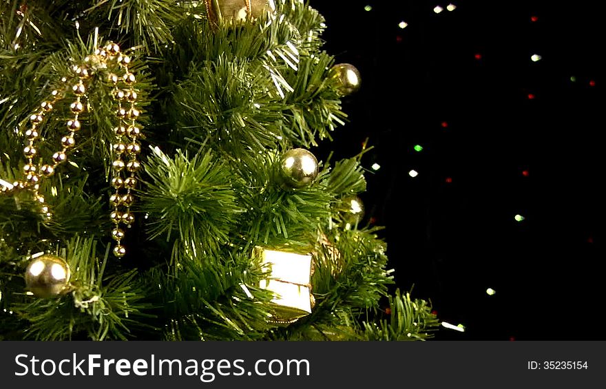 Decorated Christmas tree rotates on a black background with flashing lights