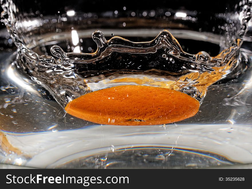 Slice of orange falling into the water. Slice of orange falling into the water