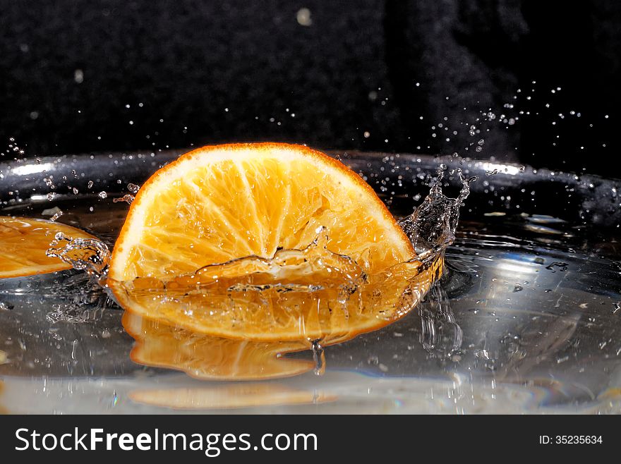 Slice of orange falling into the water. Slice of orange falling into the water