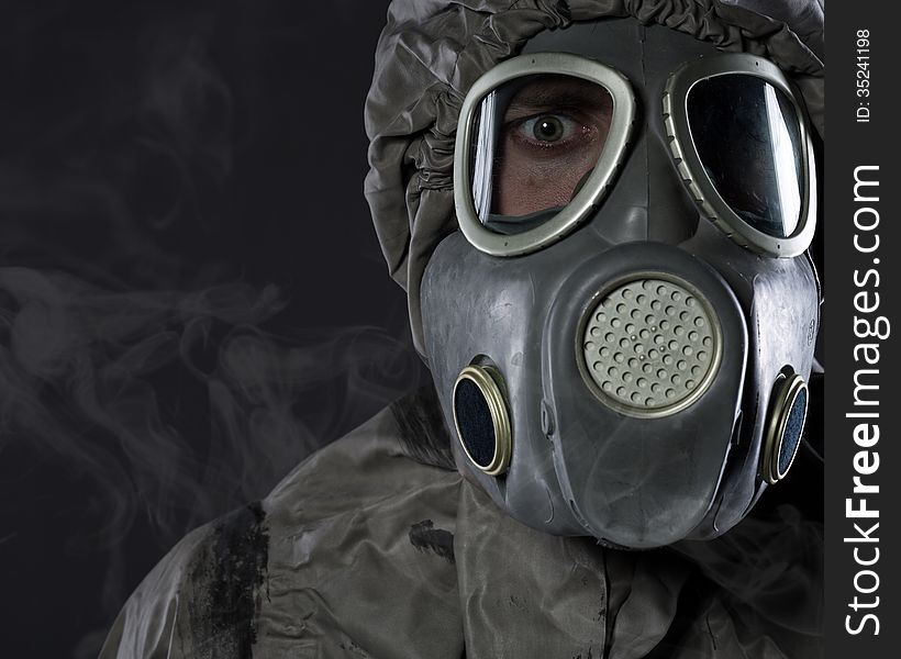 The man in a gas mask in smoke,studio