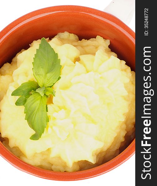 Classical Mashed Potato in Bowl Garnished with Green Basil Leafs. Top View