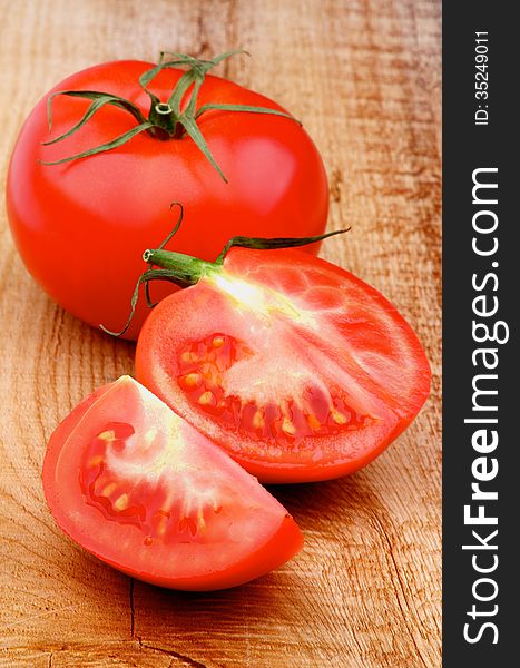 Fresh Ripe Tomatoes Full Body and Halves on Rustic Wooden background