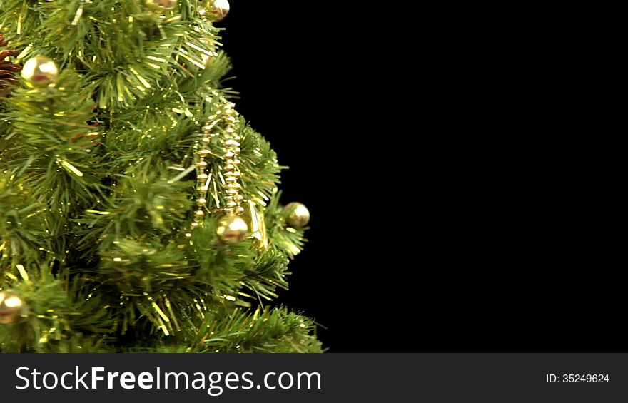 Black background. Decorated Christmas tree rotates. Focus moves to the foreground, where two wineglasses of red wine clinks. Sparkler wrote the inscription Merry Christmas!