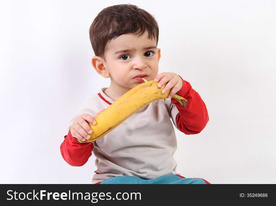 Children eating a big banana. Children eating a big banana