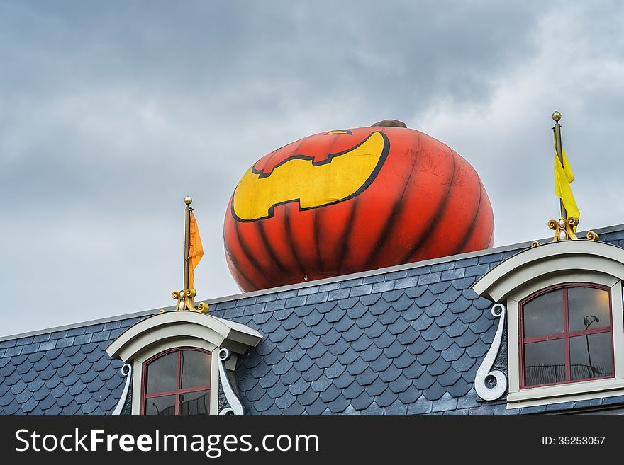 Giant pumpkin Halloween decoration on a roof. Giant pumpkin Halloween decoration on a roof