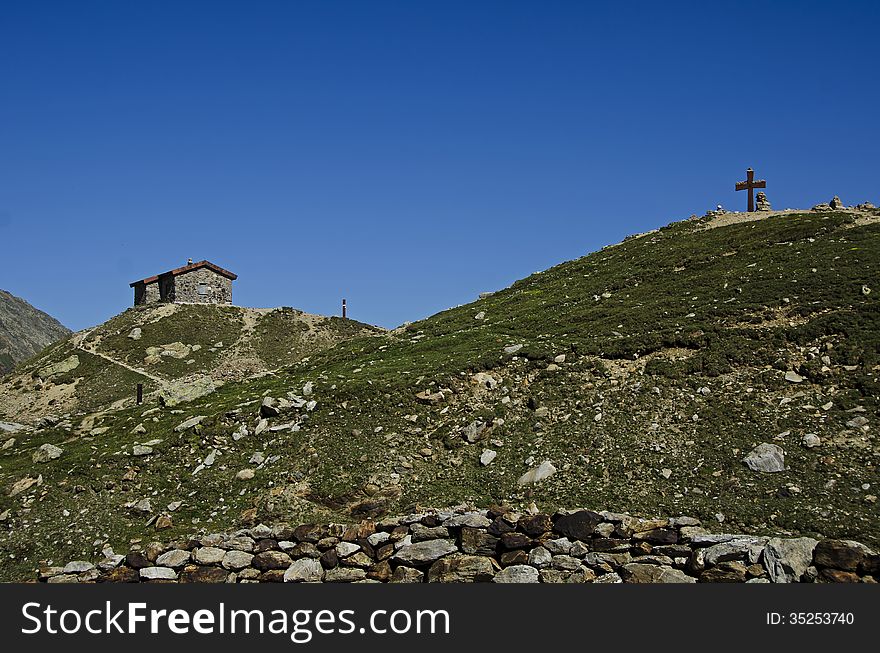 House and cross on the top mountains in a tourist route