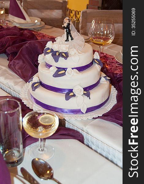 A three floored Wedding cake on a wedding table.