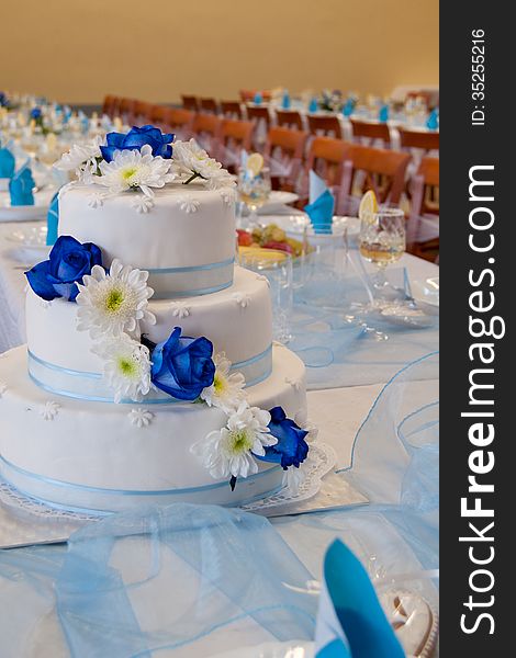 Wedding Cake with blue roses on a wedding table.