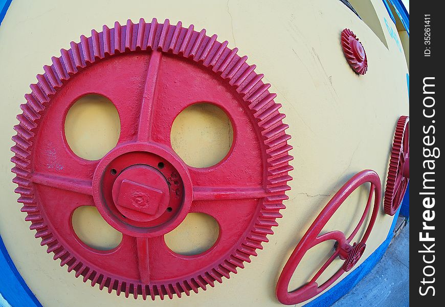 Red gear fixed on the yellow wall of a garage mechanic - Amazonia - Brazil