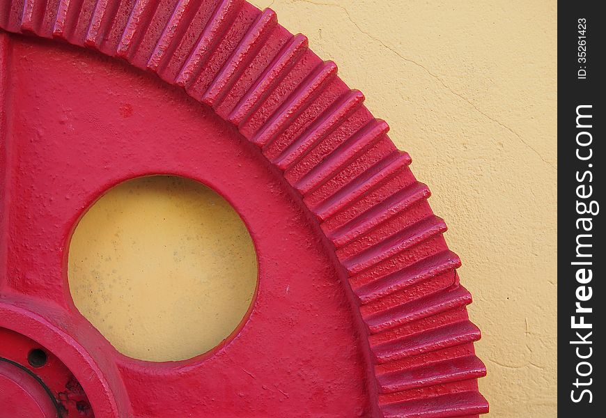 Red gear fixed on the yellow wall of a garage mechanic - Amazonia - Brazil