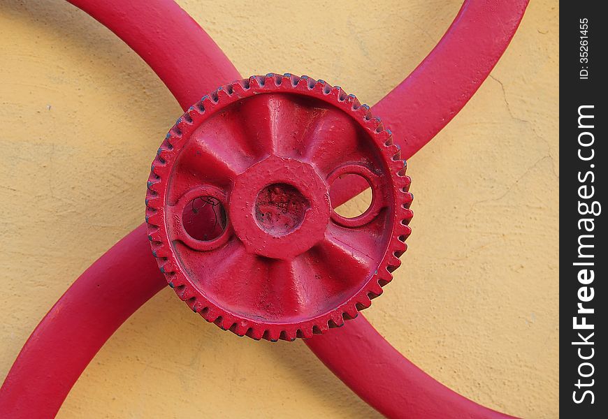 Red gear fixed on the yellow wall of a garage mechanic - Amazonia - Brazil