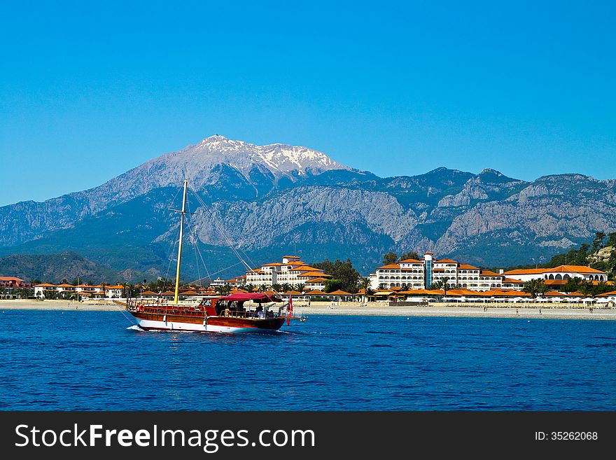 Sailing Yacht Sail Through The Sea On The Background Of Mountains