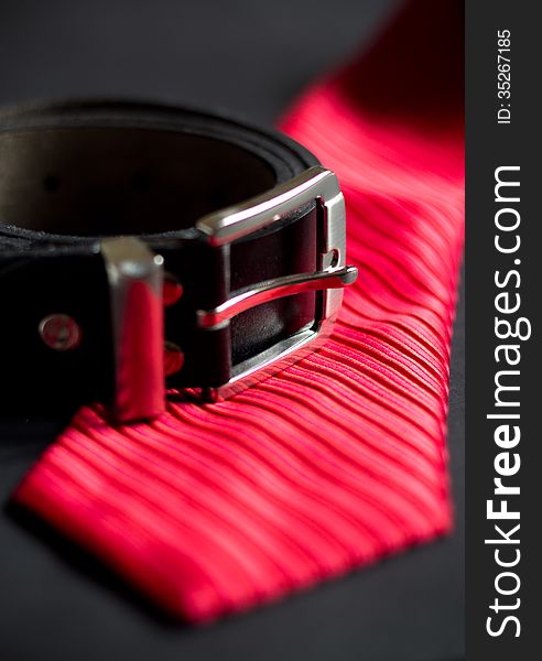 Red necktie and leather belt. Red necktie and leather belt