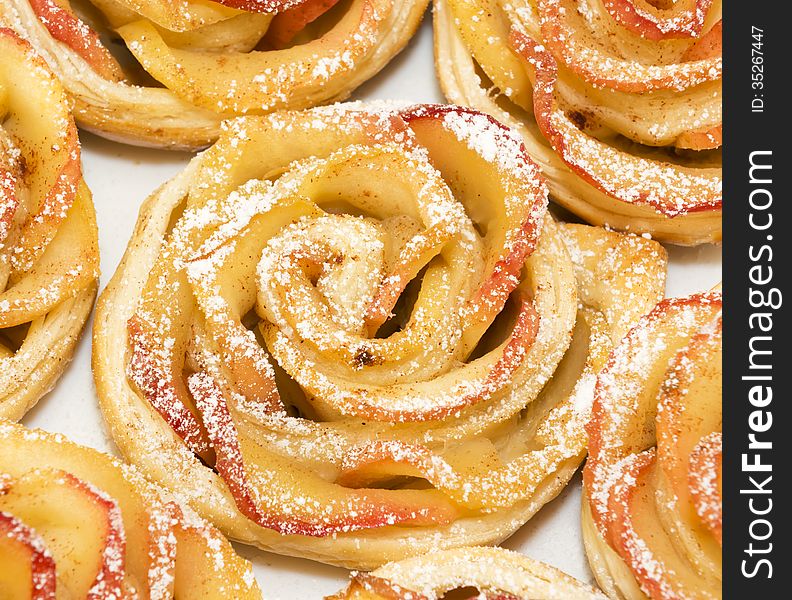 Sweet rolls with apples in the form of roses on white plate. Sweet rolls with apples in the form of roses on white plate