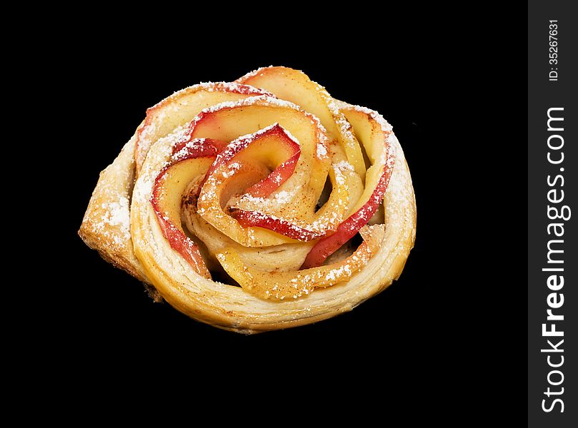 Sweet roll with apples in the form of roses on black  background