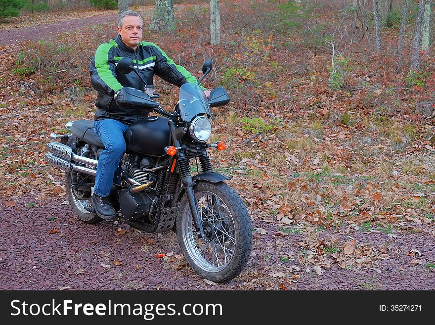 A man is shown on his motorcycle in the woods enjoying his sport and the outdoors. A man is shown on his motorcycle in the woods enjoying his sport and the outdoors.