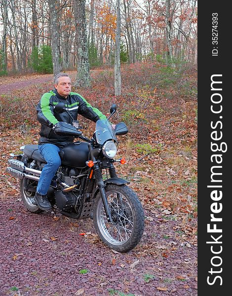 A man is shown on his motorcycle in the woods enjoying his sport and the outdoors. A man is shown on his motorcycle in the woods enjoying his sport and the outdoors.