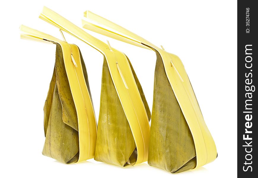 Arrange of three banana leaves package with long coconut leaves tail of Thai dessert on white background. Arrange of three banana leaves package with long coconut leaves tail of Thai dessert on white background