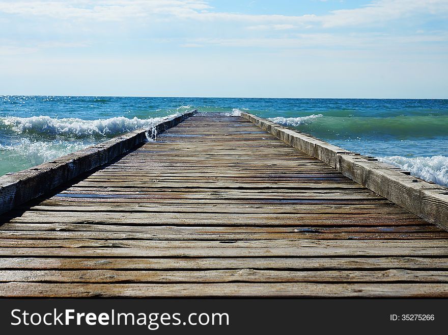 Wooden pier leading into the blue sea