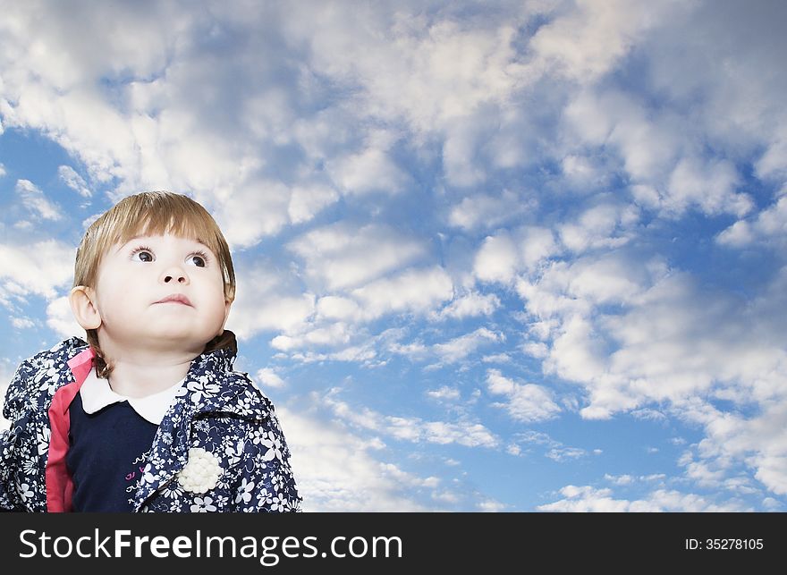 The girl of 1 year looks up against the blue sky. The girl of 1 year looks up against the blue sky.