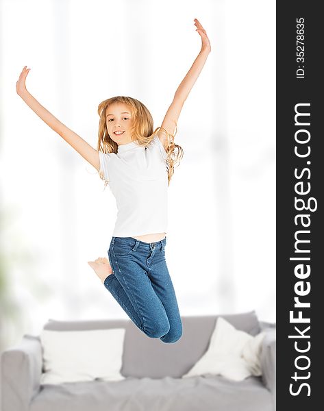 Happy child girl jumping indoors