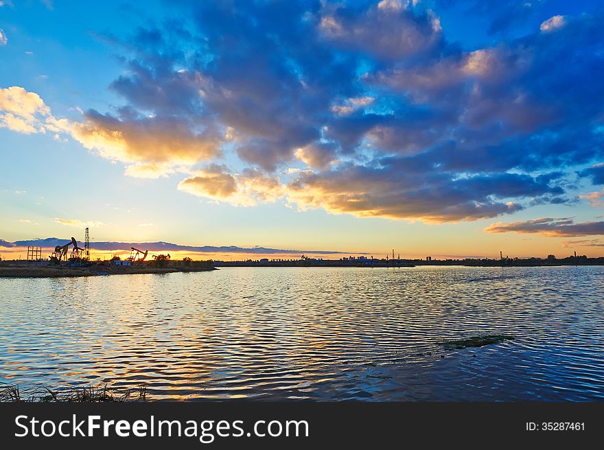 The Oil fields in the afterglow lake and cloudscape